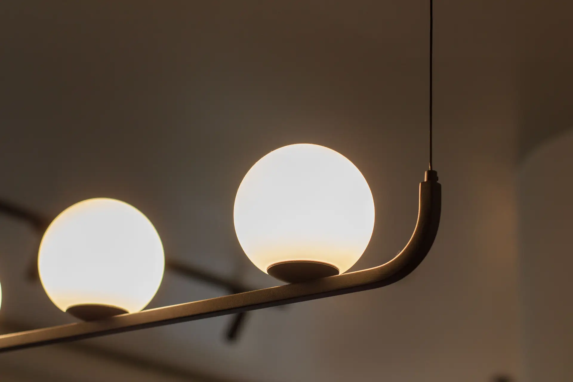 Sculptural minimalist pendant luminaire in warm architectural setting