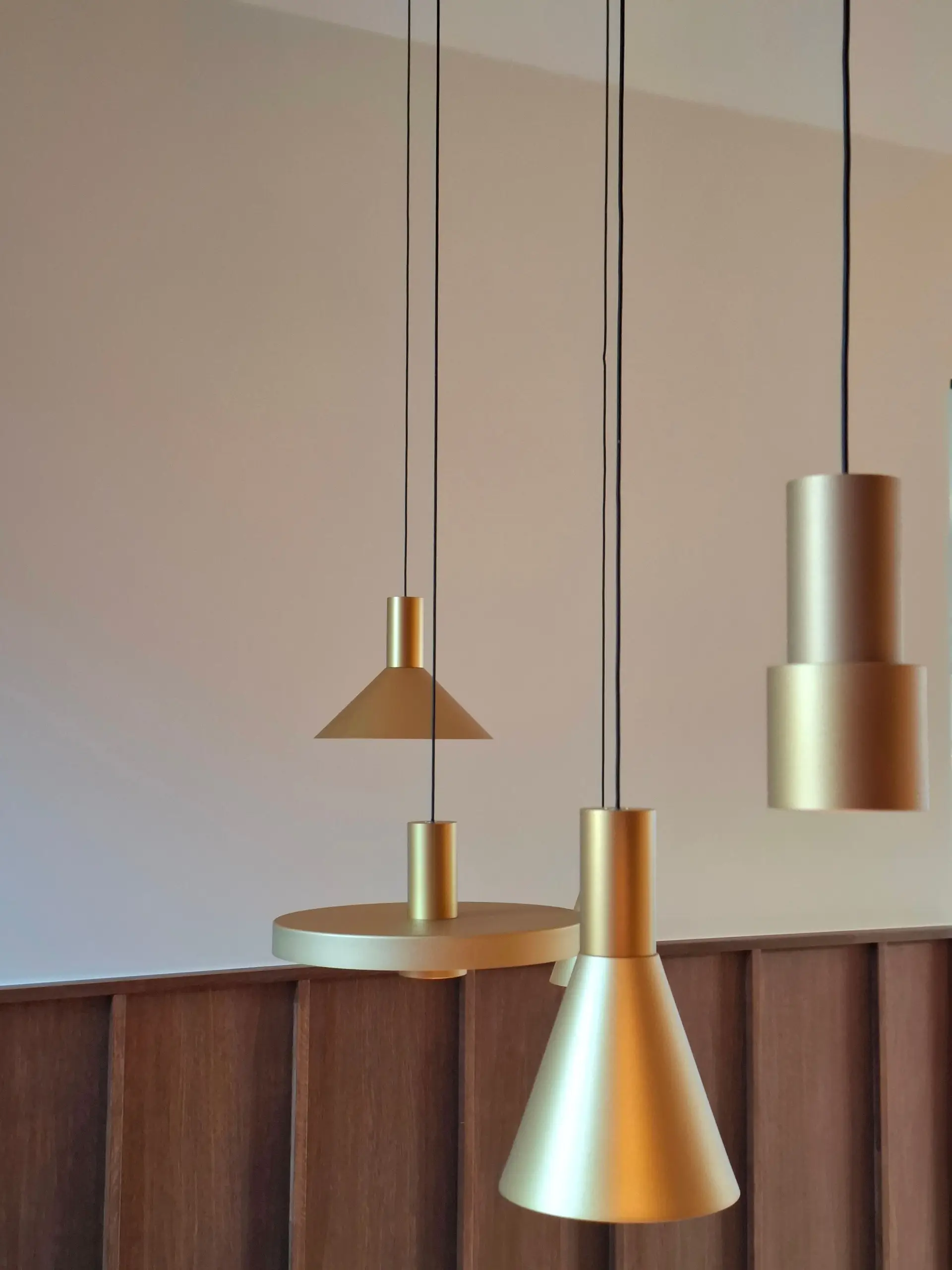 Detail of spun brass pendant fixture with warm light