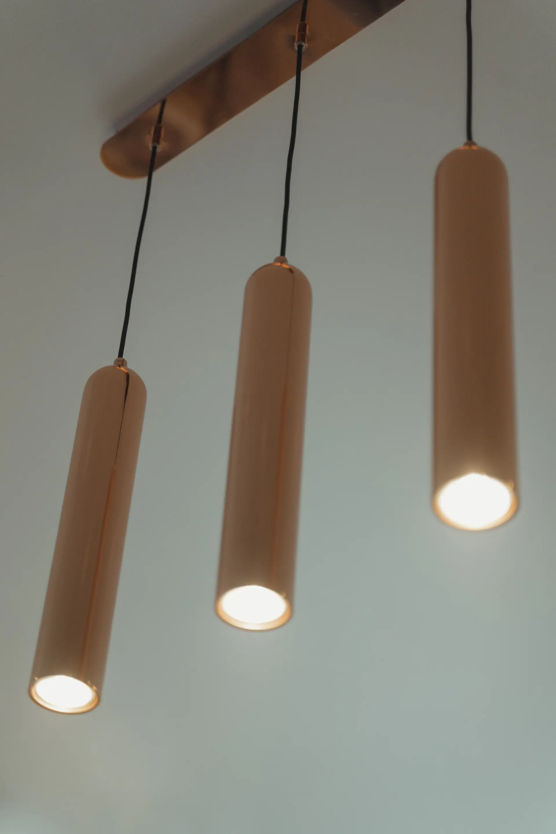 Minimalist brass cylinder pendant installation detail